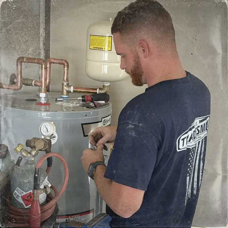 A plumber services a water heater in Pensacola.