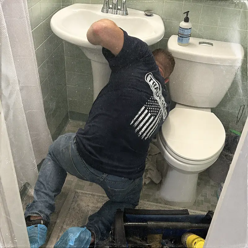 A plumber services a sink.